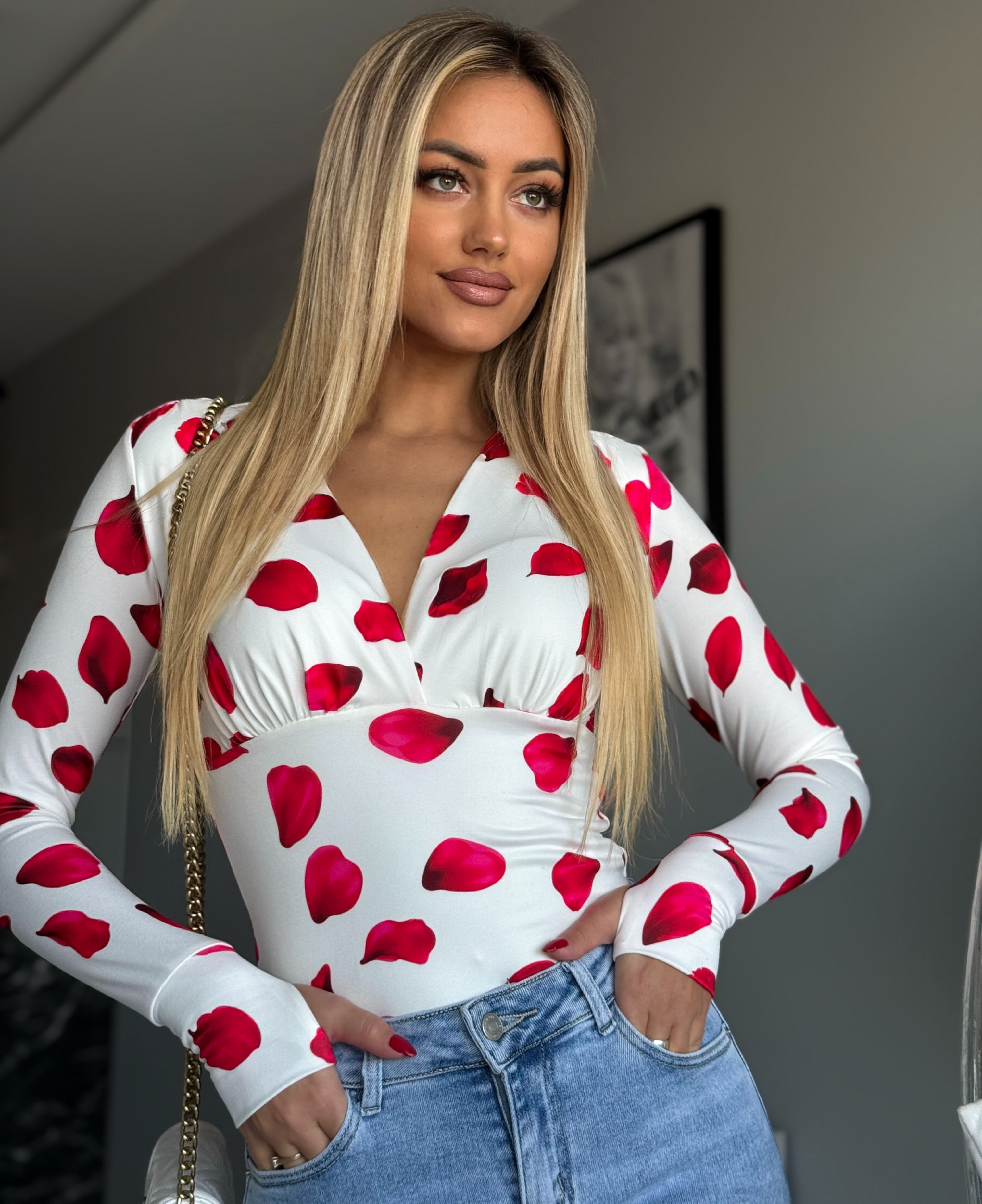 Punased lehekesed valgel taustal v-kaelusega pluus