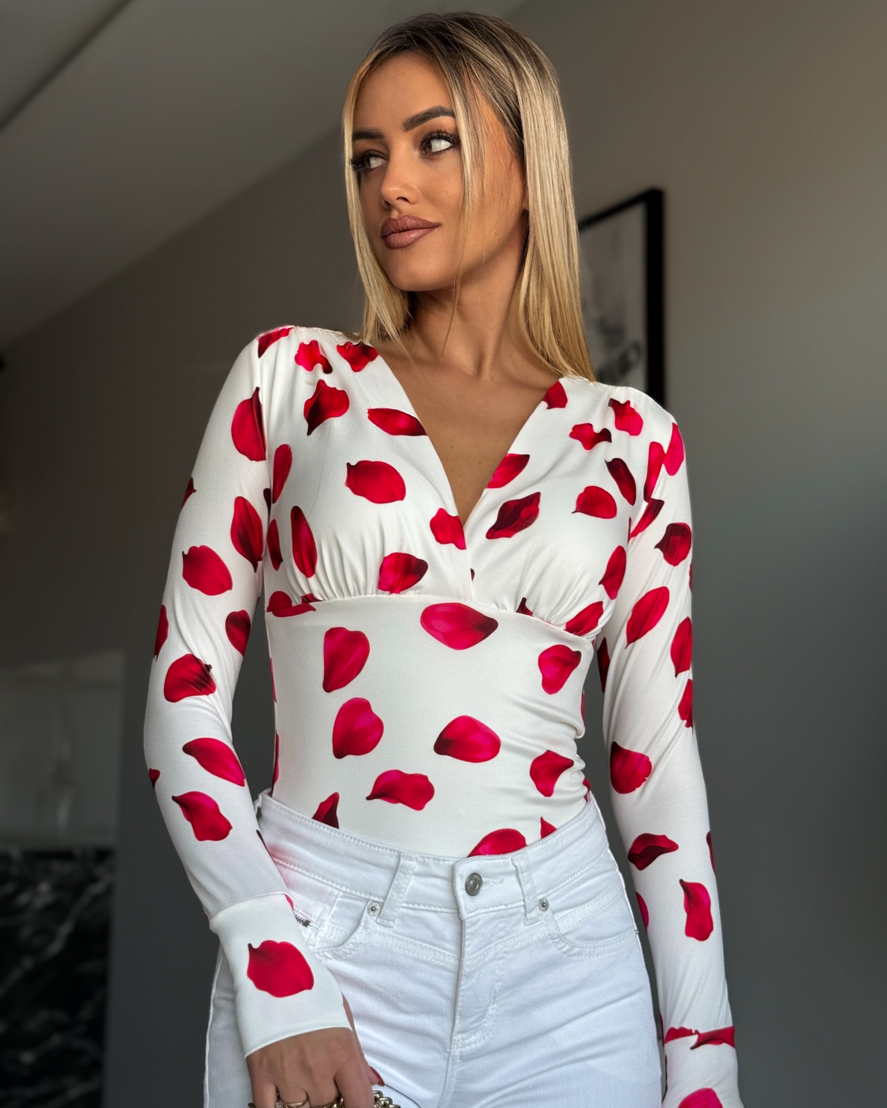 Punased lehekesed valgel taustal v-kaelusega pluus