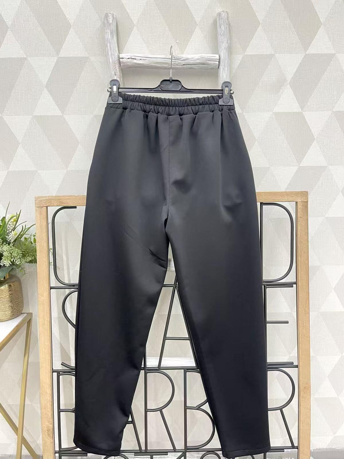 Mustad püksid läikivate nööpidega