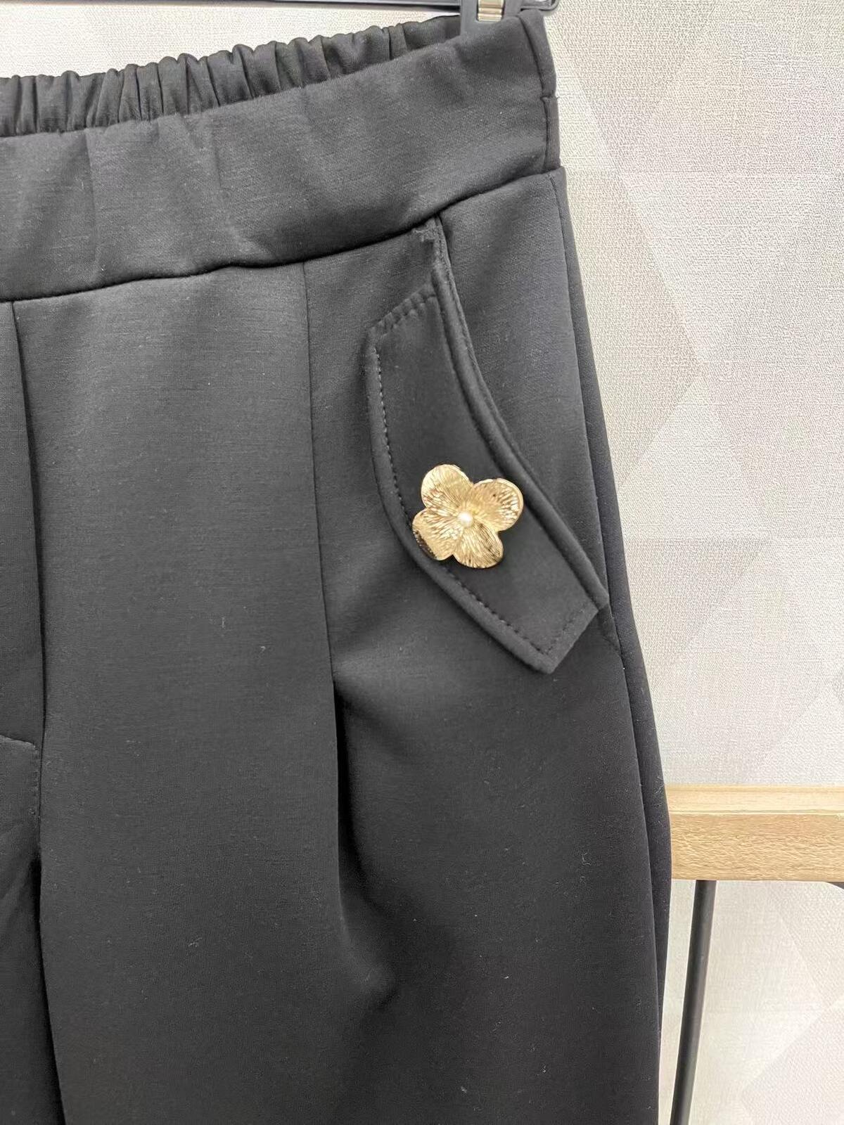 Mustad püksid läikivate nööpidega