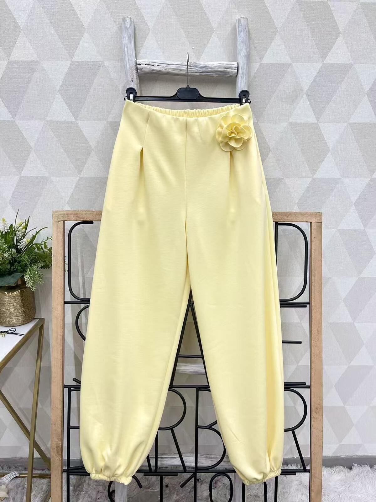 Kollased laiad püksid roosi kaunistusega