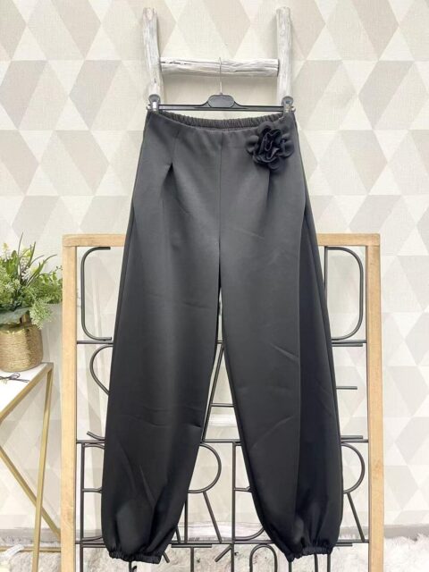 Mustad laiad püksid roosi kaunistusega