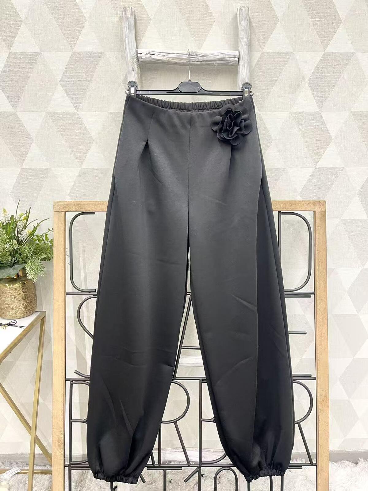 Mustad laiad püksid roosi kaunistusega